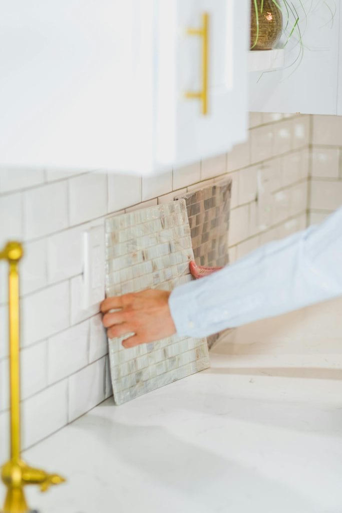 Person installing kitchen backsplash tiles